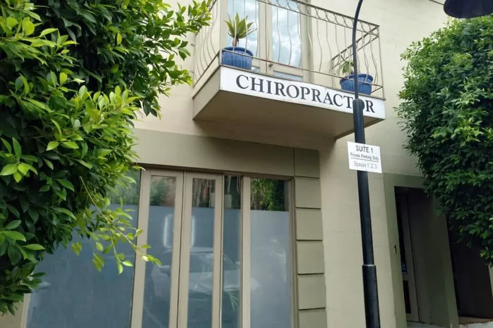 Auburn Chiropractic Centre exterior in Hawthorn — Chiropractor signage above Suite 1, leafy streetscape